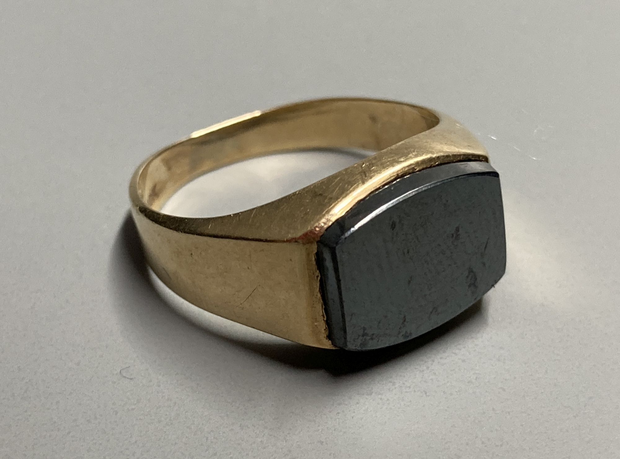 A modern 10k yellow metal and hematite set signet ring, size Q, gross 5.8 grams.